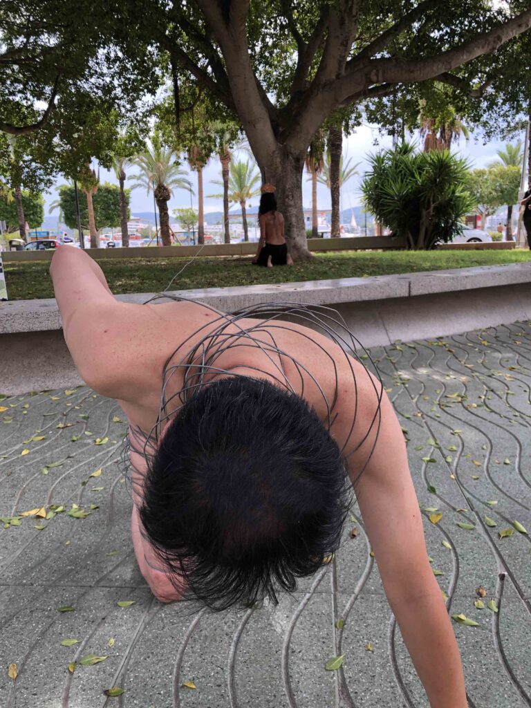 Philemon Mukarno perform naked involves him entangling his body with thick iron wires, which feel oppressive and heavy, and every movement causes pain due to the iron wires.