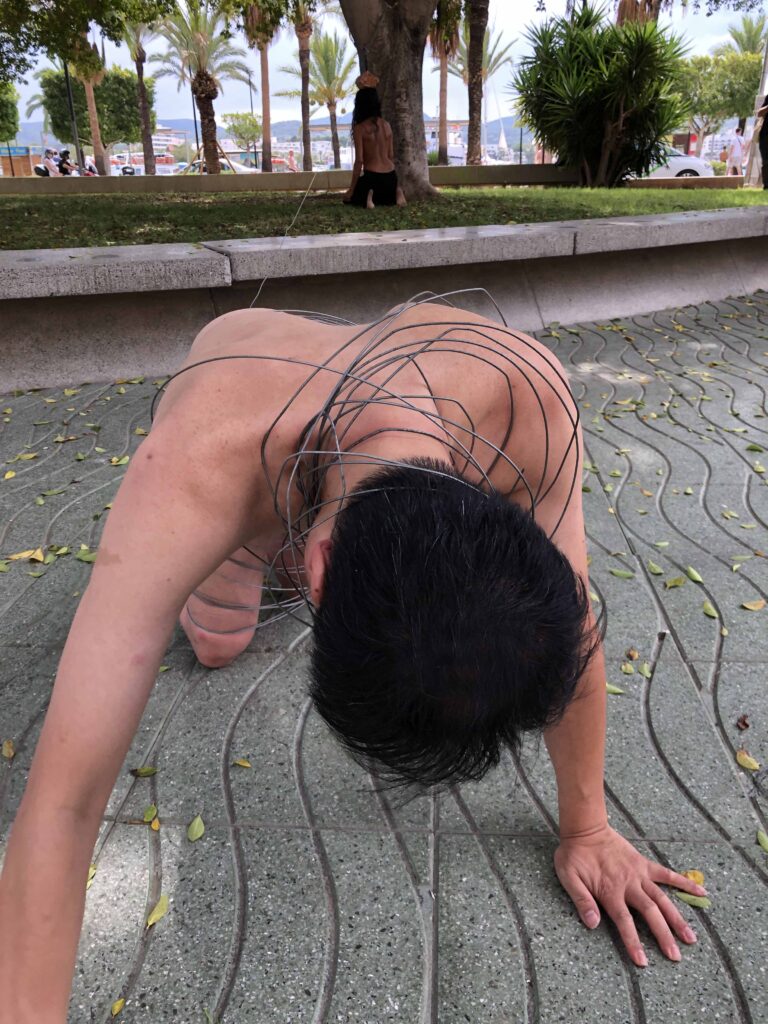 Philemon Mukarno perform naked involves him entangling his body with thick iron wires, which feel oppressive and heavy, and every movement causes pain due to the iron wires.