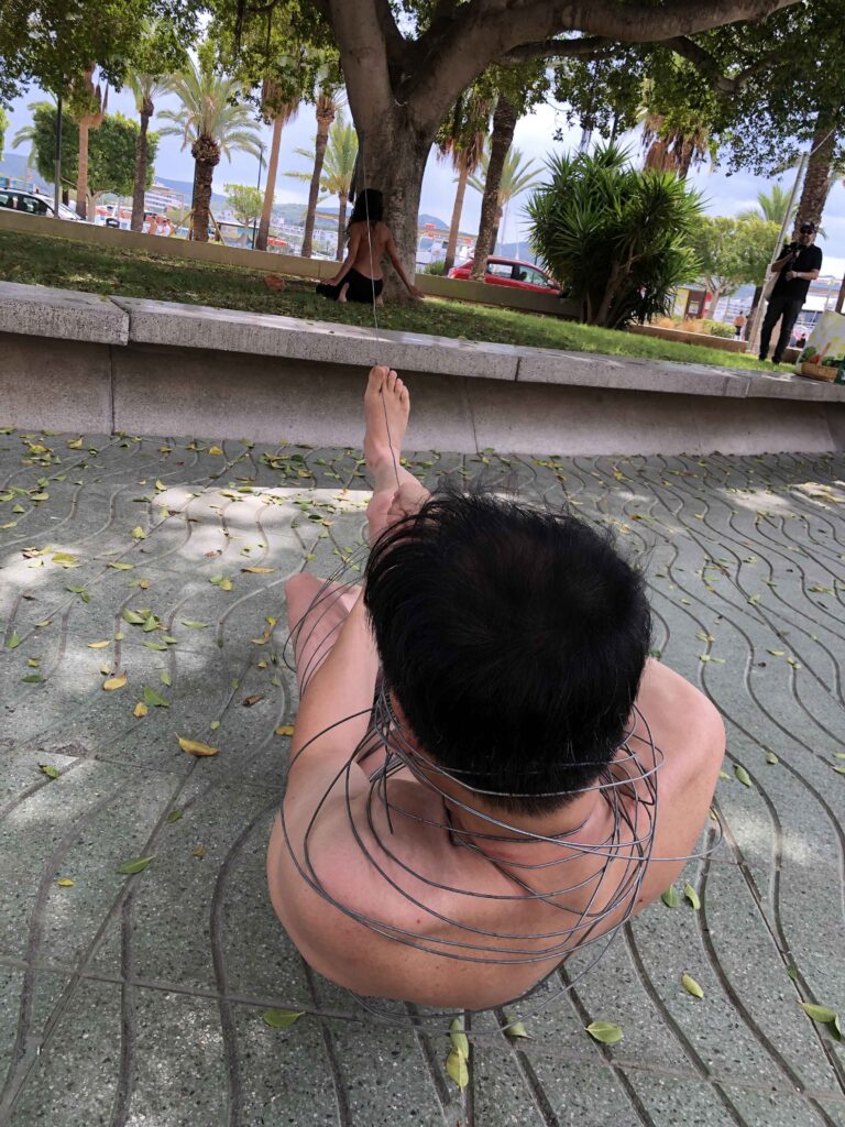 Philemon Mukarno perform naked involves him entangling his body with thick iron wires, which feel oppressive and heavy, and every movement causes pain due to the iron wires.