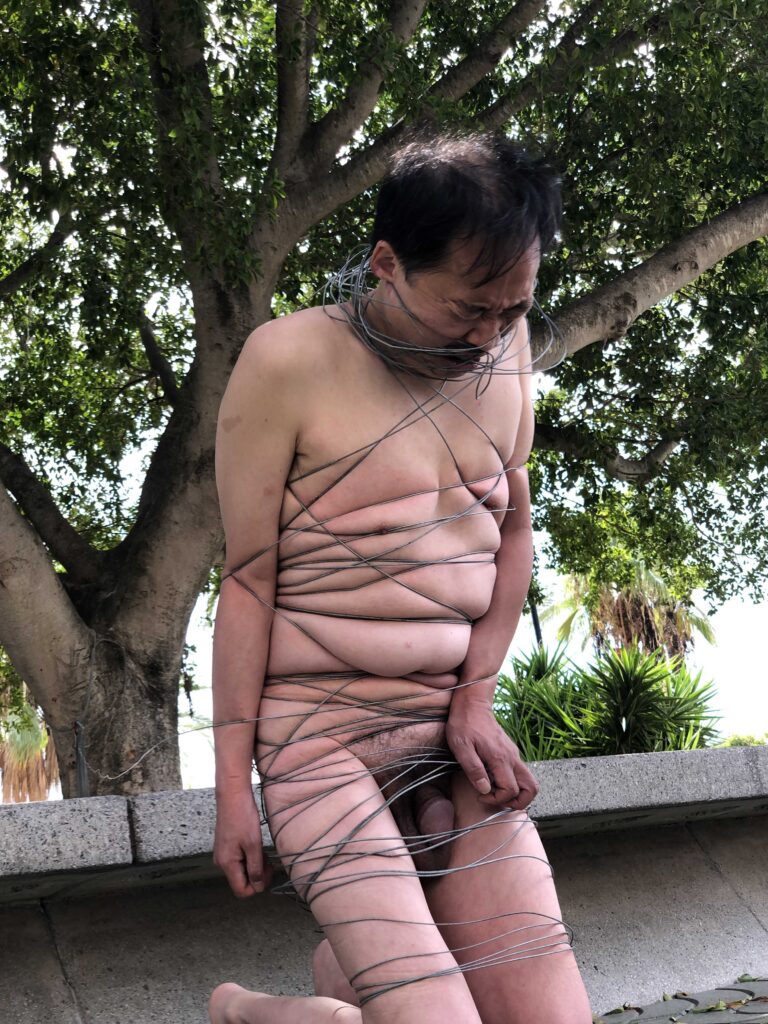 Philemon Mukarno perform naked involves him entangling his body with thick iron wires, which feel oppressive and heavy, and every movement causes pain due to the iron wires.