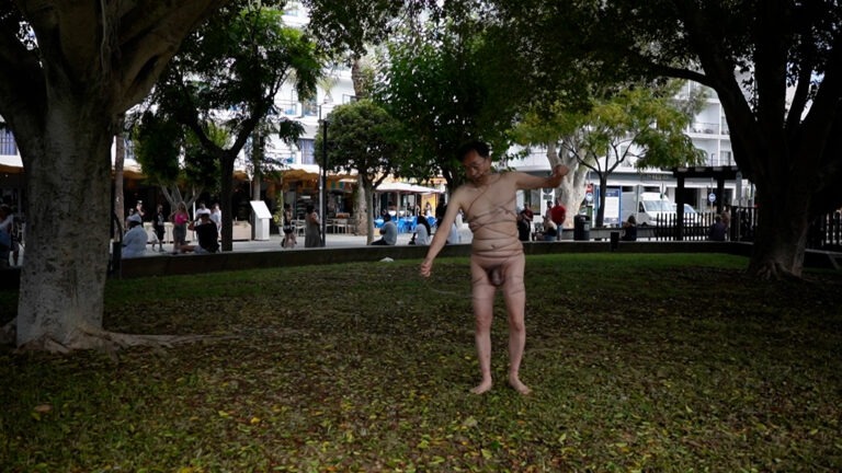 Philemon Mukarno perform naked involves him entangling his body with thick iron wires, which feel oppressive and heavy, and every movement causes pain due to the iron wires.