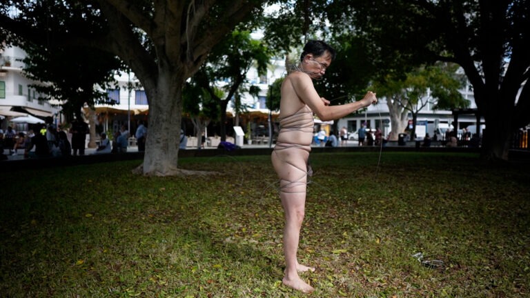 Philemon Mukarno perform naked involves him entangling his body with thick iron wires, which feel oppressive and heavy, and every movement causes pain due to the iron wires.