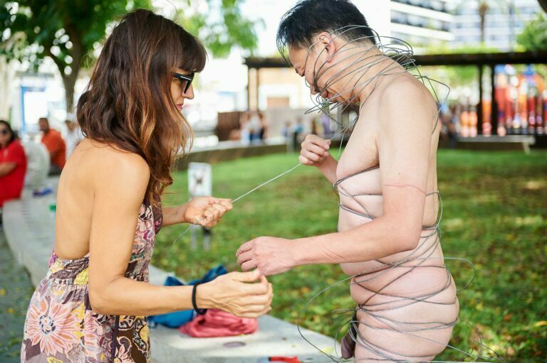 Philemon Mukarno perform naked involves him entangling his body with thick iron wires, which feel oppressive and heavy, and every movement causes pain due to the iron wires.