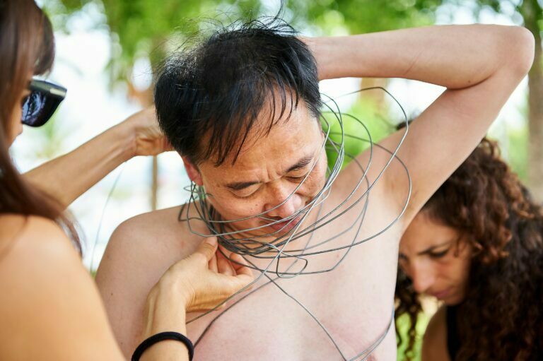 Philemon Mukarno perform naked involves him entangling his body with thick iron wires, which feel oppressive and heavy, and every movement causes pain due to the iron wires.