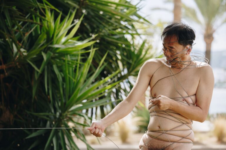 Philemon Mukarno perform naked involves him entangling his body with thick iron wires, which feel oppressive and heavy, and every movement causes pain due to the iron wires.