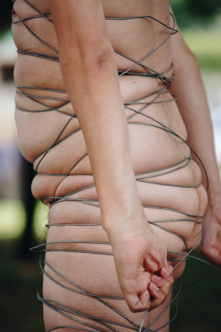 Philemon Mukarno perform naked involves him entangling his body with thick iron wires, which feel oppressive and heavy, and every movement causes pain due to the iron wires.