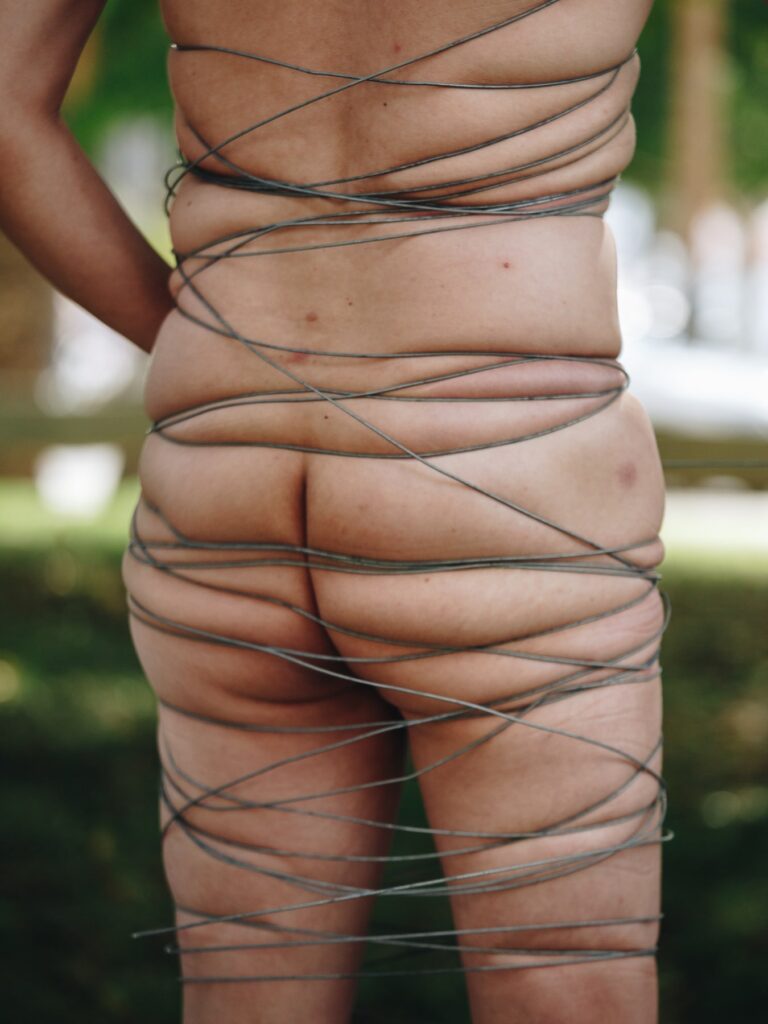 Philemon Mukarno perform naked involves him entangling his body with thick iron wires, which feel oppressive and heavy, and every movement causes pain due to the iron wires.