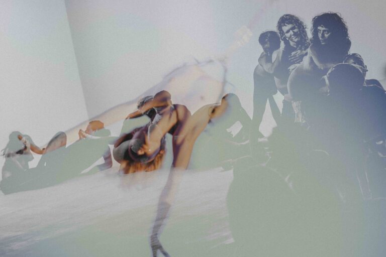 Een artistieke weergave van dansers in verschillende poses, waarbij hun lichamen vervagen en overlappen. De achtergrond toont silhouetten van andere dansers en een abstracte verlichting, wat een gevoel van beweging en expressie oproept.