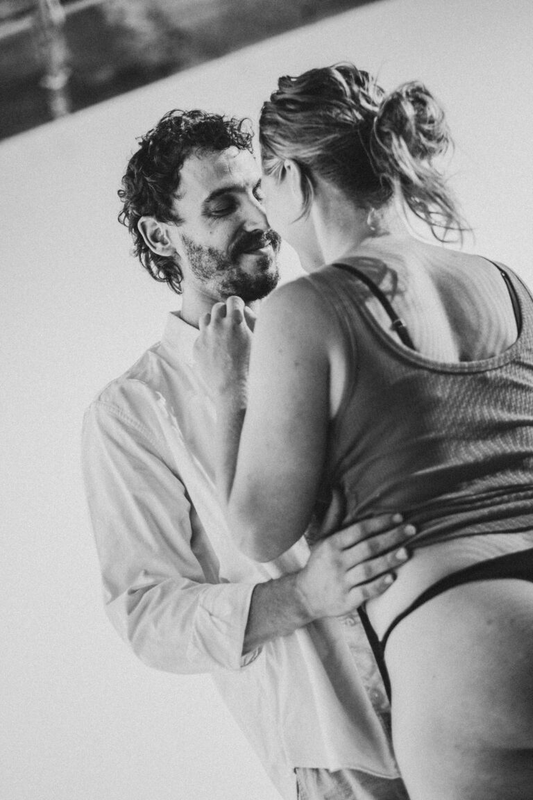 Man and woman in an intimate pose with woman looking away in black and white