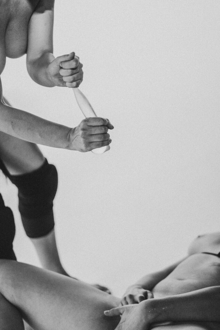 Two naked people in a combative pose holding hands in black and white with focus on arms and hands