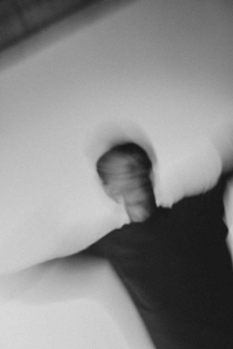 Blurred black and white photo of a naked person in dynamic motion with arms extended