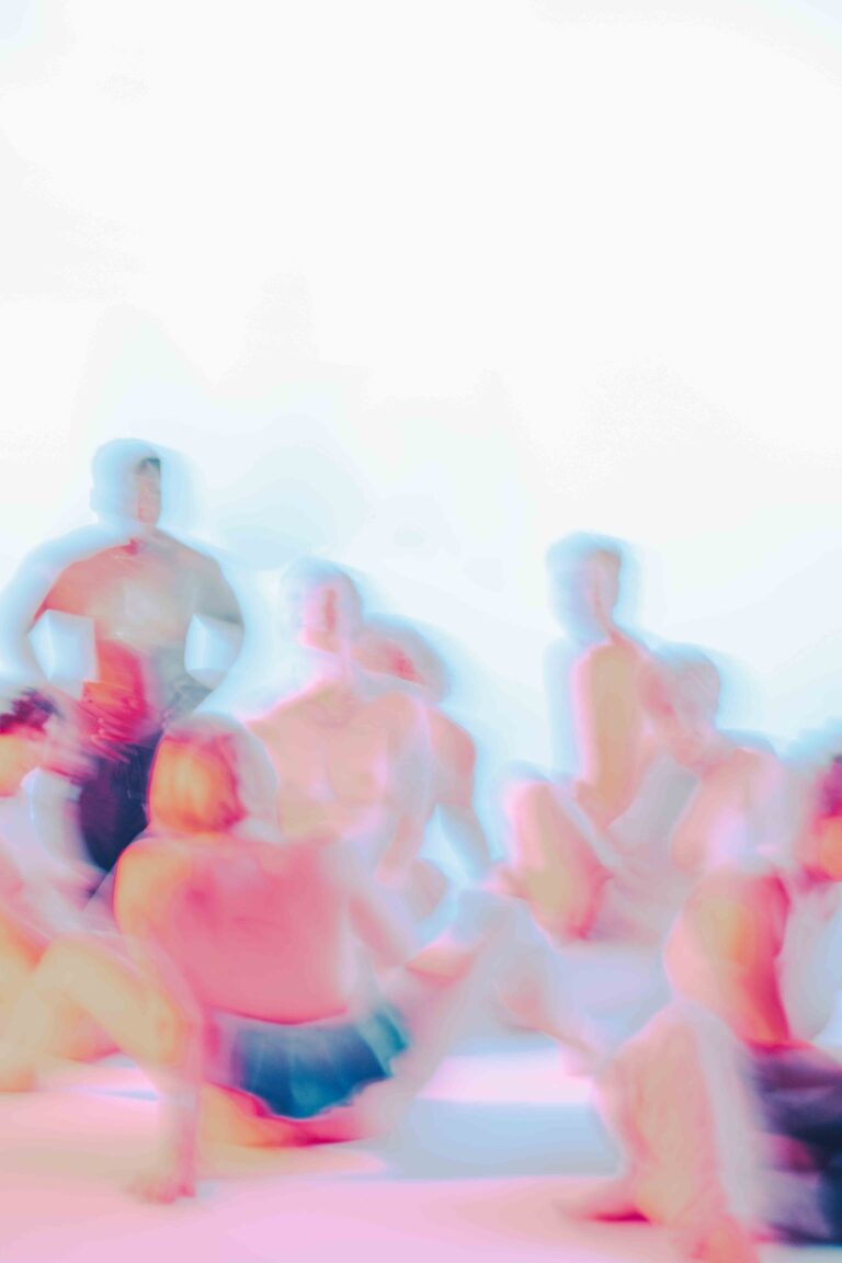 An abstract depiction of a group of nude people in a bright environment, visible in vague, colorful sketches with a mix of pink and blue, evoking a sense of movement and dynamism.