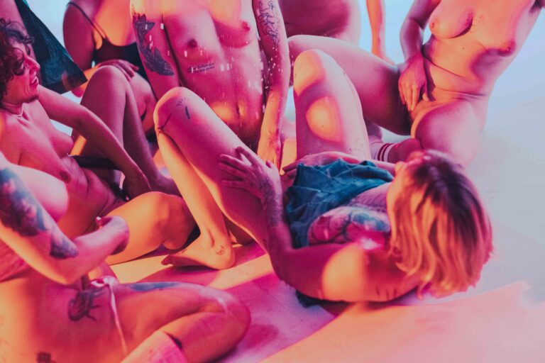 Een persoon in beweging met een rode top en een gestreepte blouse, tegen een wazige achtergrond, wat een gevoel van dynamiek en energie oproept.