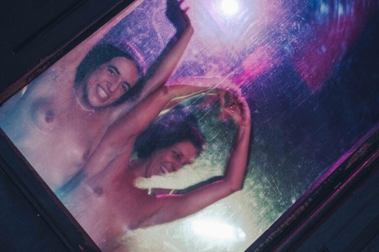 Een persoon in beweging met een rode top en een gestreepte blouse, tegen een wazige achtergrond, wat een gevoel van dynamiek en energie oproept.