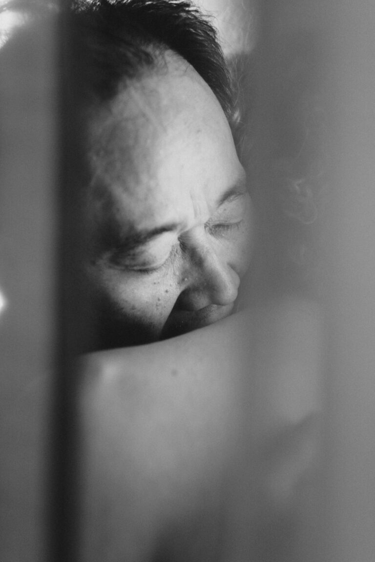 Close-up black and white portrait of Philemon Mukarno with closed eyes and contemplative expression