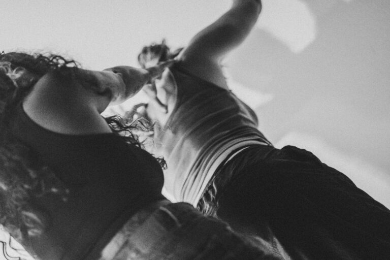 Bewegende blote voeten en benen van verschillende mensen, met enkele benen gekleed in zwarte sokken, op een lichte achtergrond.