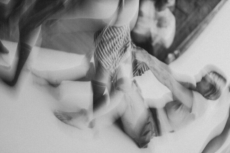 Bewegende blote voeten en benen van verschillende mensen, met enkele benen gekleed in zwarte sokken, op een lichte achtergrond.