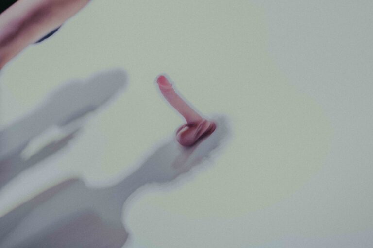 Een persoon in beweging met een rode top en een gestreepte blouse, tegen een wazige achtergrond, wat een gevoel van dynamiek en energie oproept.