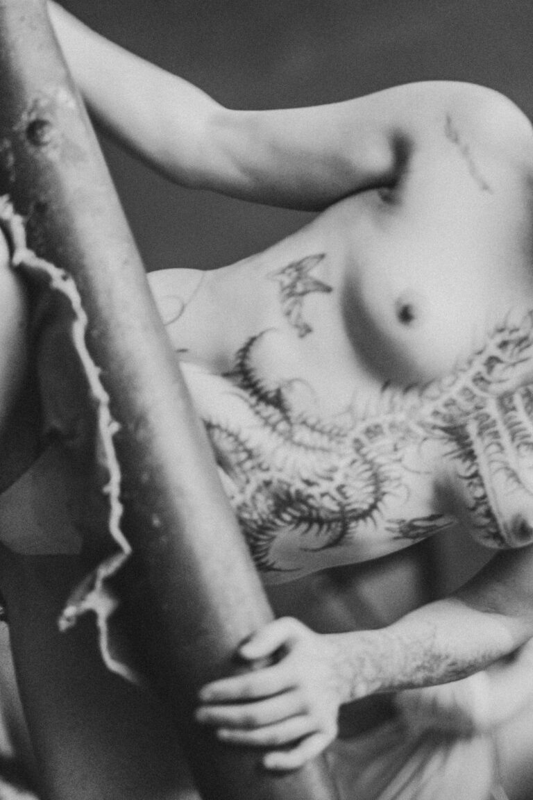 Close-up of a naked torso with tattoos and body art