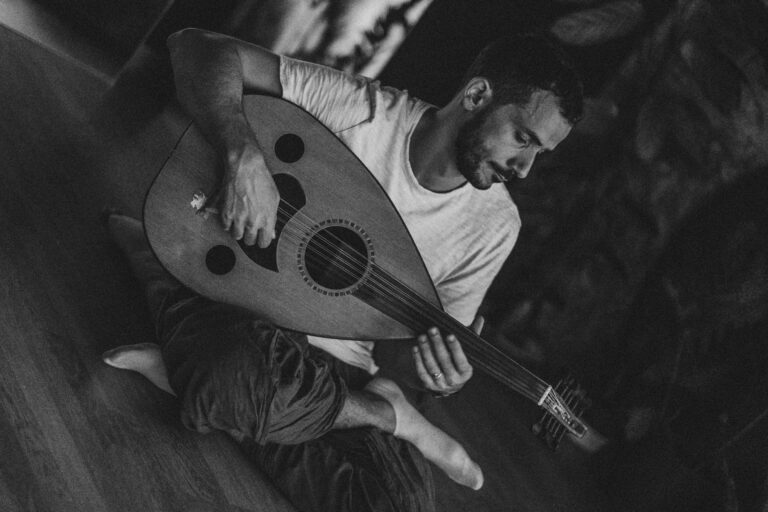 A man sits on the ground with crossed legs and